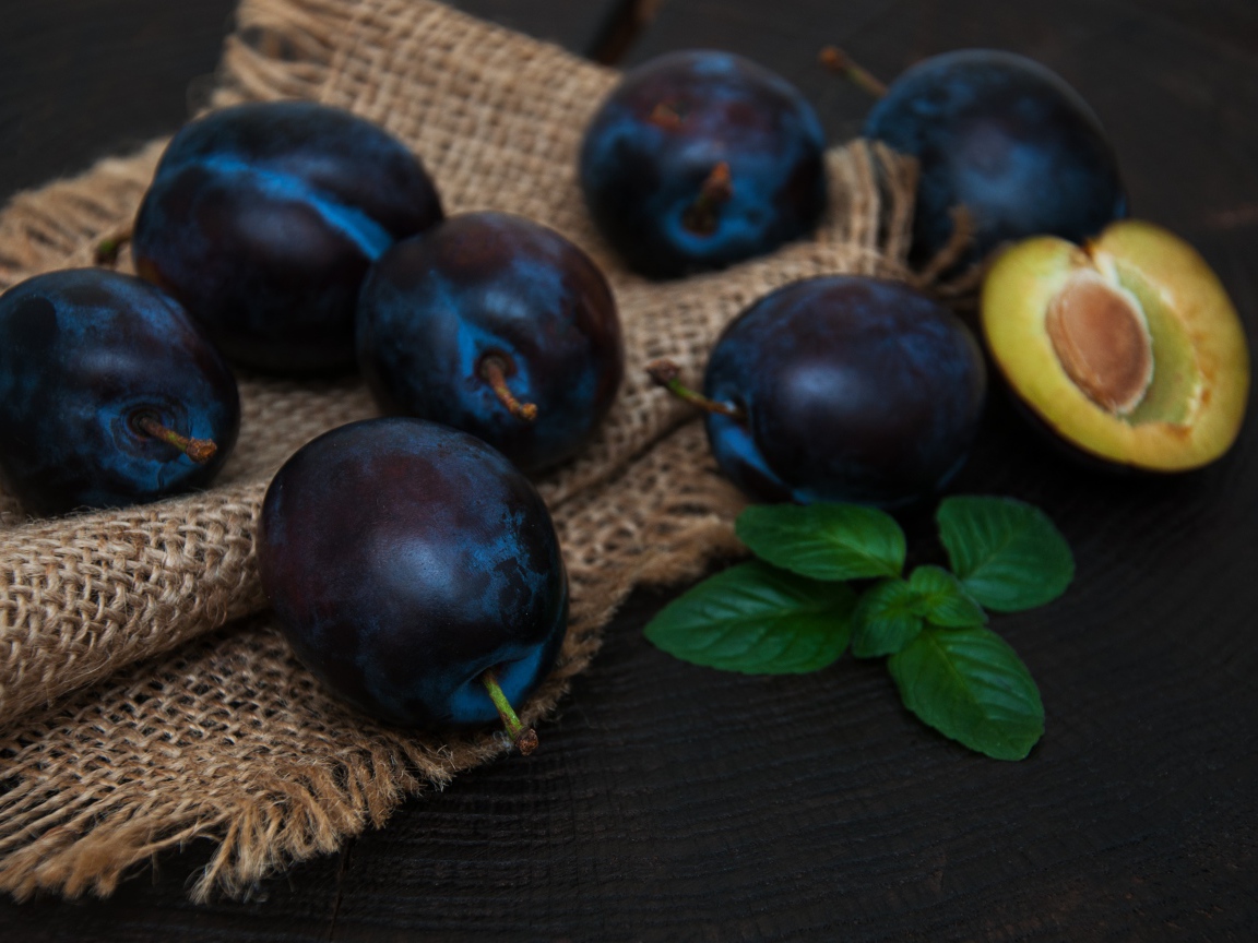 Спелые синие сливы на столе