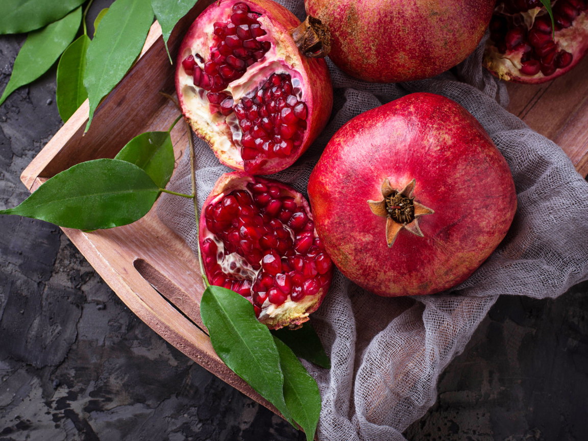 Спелые красные гранаты в деревянном ящике