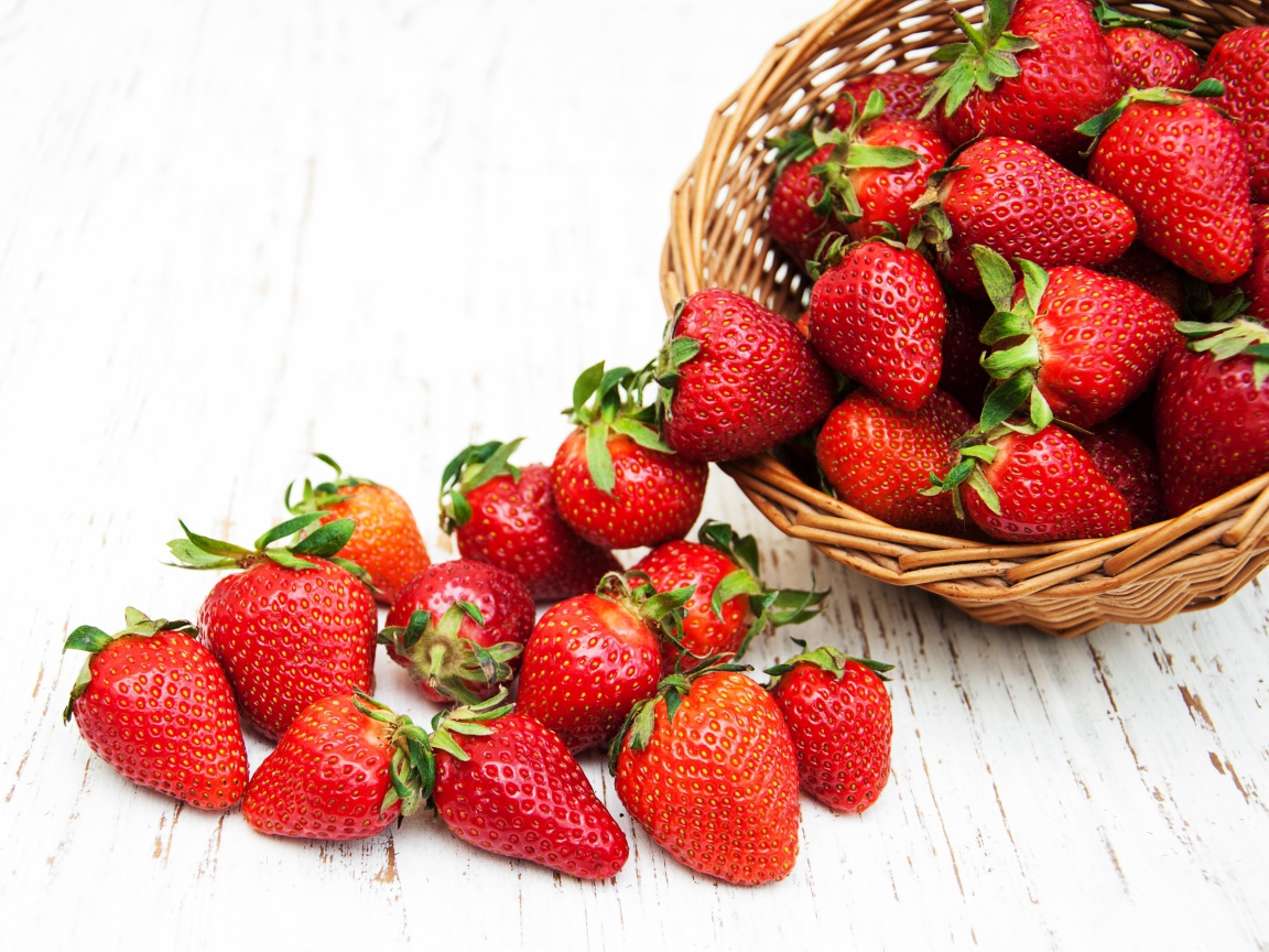 Клубника в корзине на деревянном столе