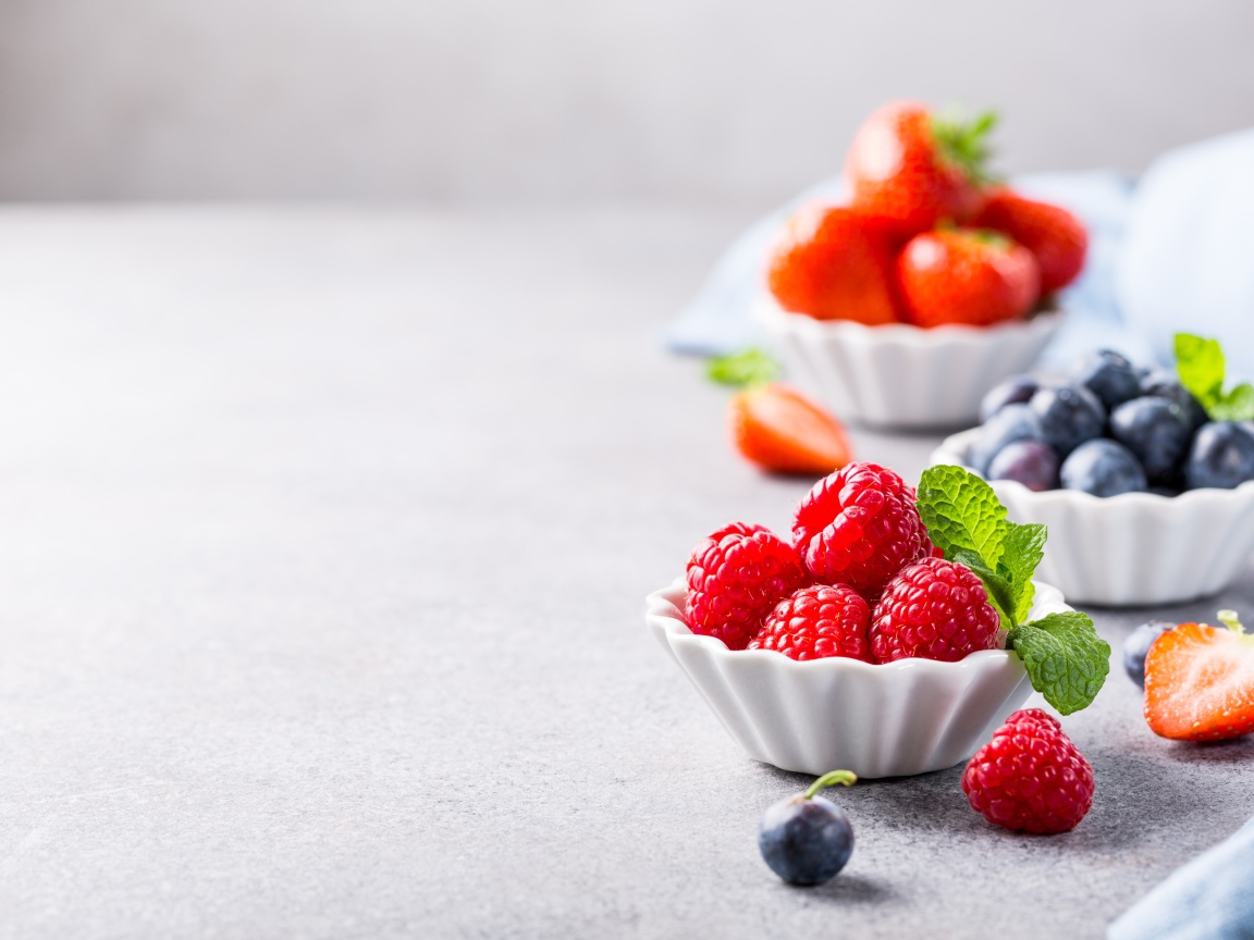 Ягоды клубники, малины и черники на столе 