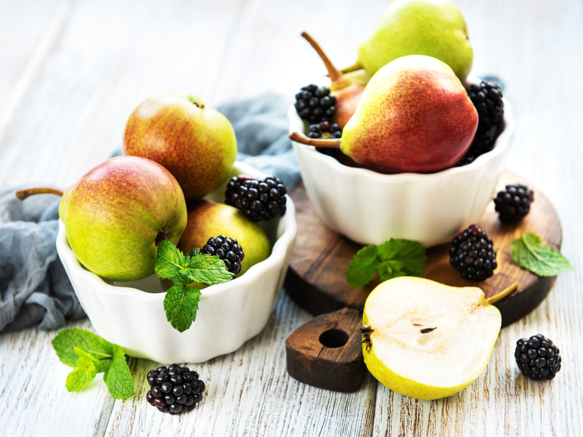 Вкусные груши на столе с ягодами ежевики