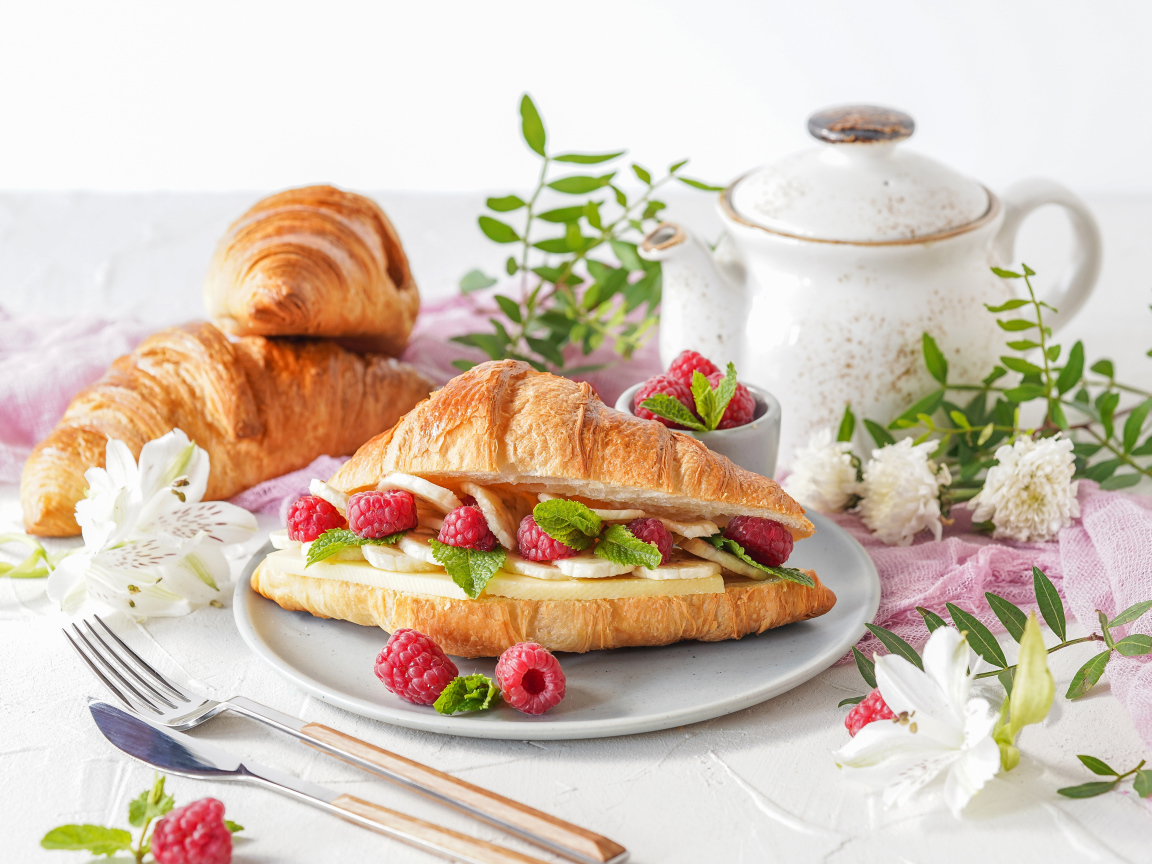 Бутерброд из круассана с ягодами малины и бананами