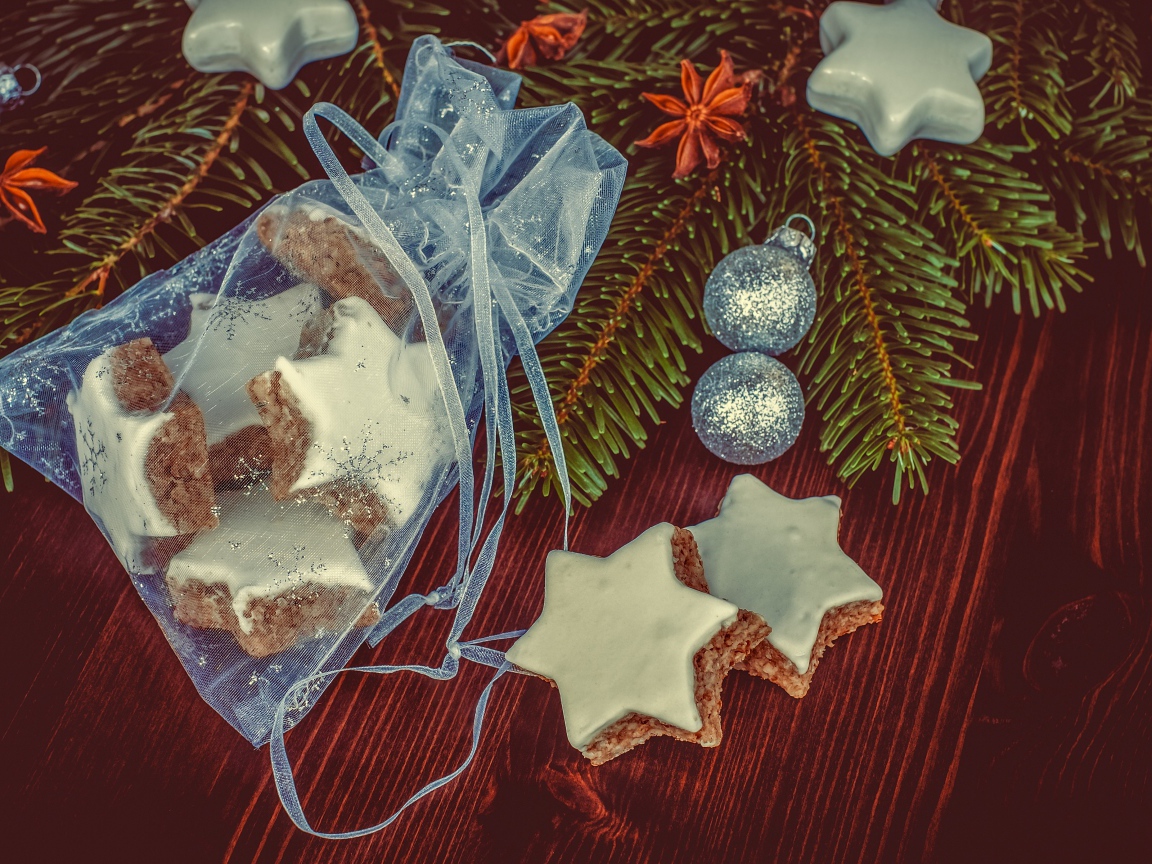 Аппетитное печенье звездочки в мешочке на столе с еловой веткой
