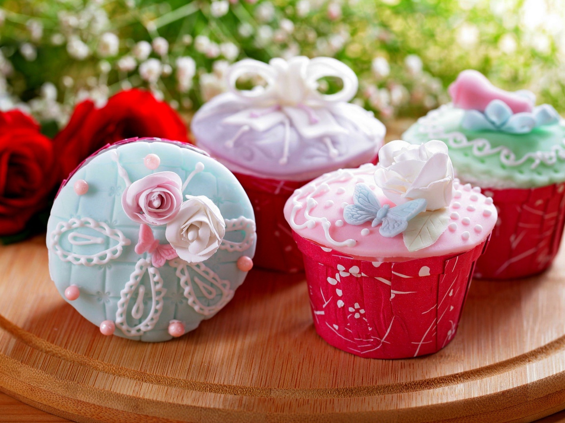 Красиво украшенные кексы на доске с цветами