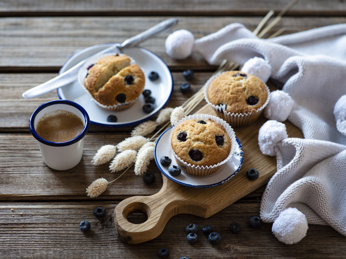 Кексы с черникой на столе с колосьями и кофе