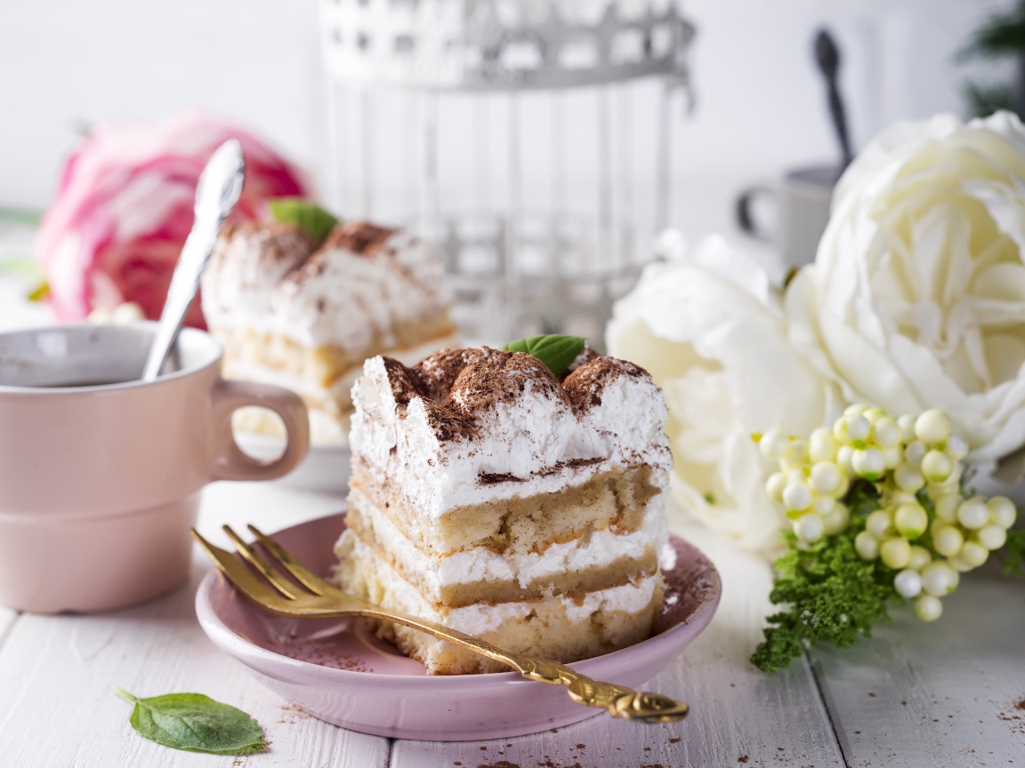 Пирожное на столе с кофе и цветами 