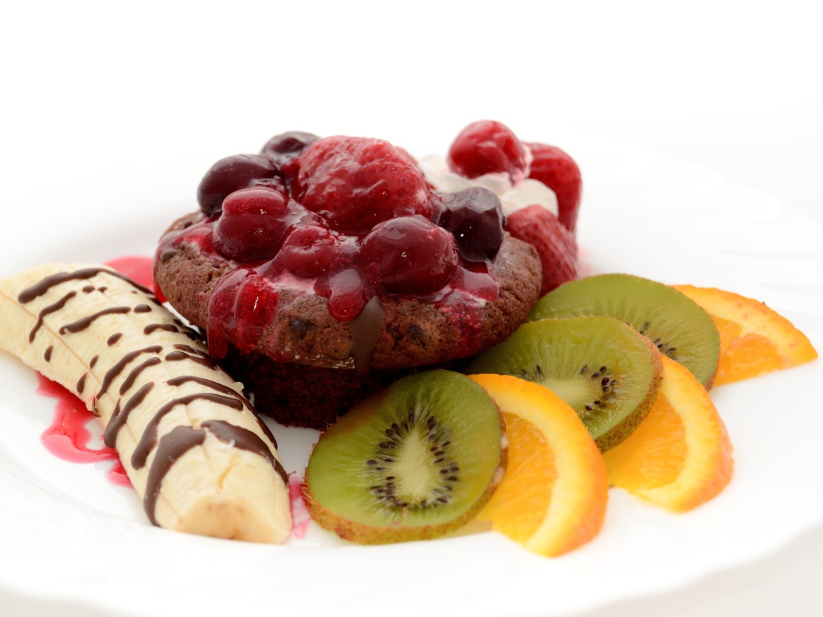 Печенье с вареньем, кусочками банана, киви и апельсина на белом фоне