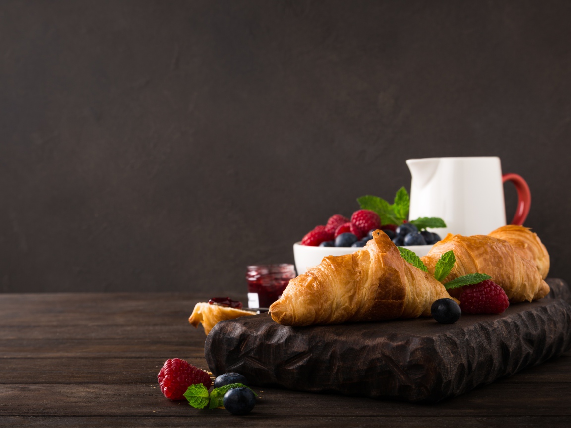 Круассаны на столе с ягодами и джемом 