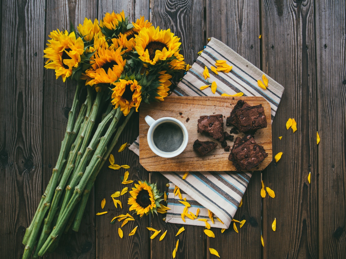 Cup of coffee on the table with a pie and a bouquet of sunflowers
