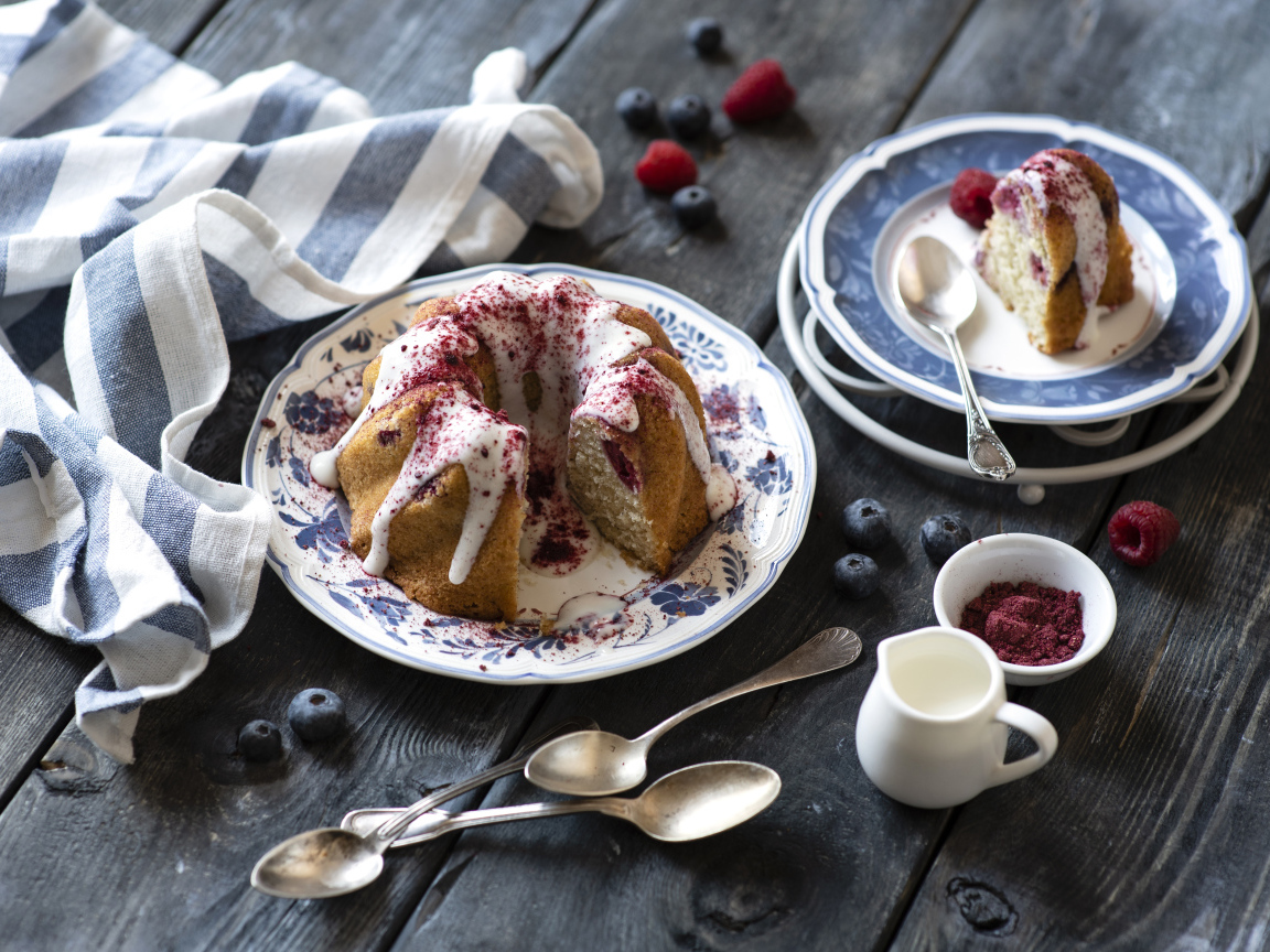 Кекс с кремом и ягодами на столе 