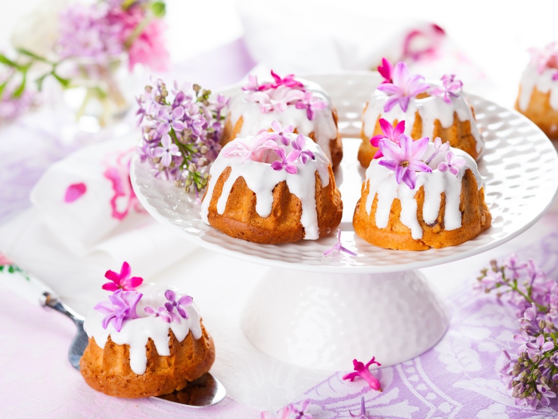 Кексы с глазурью на подносе с цветами сирени 