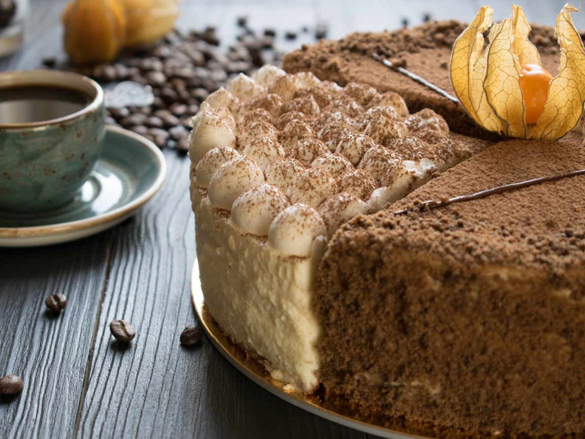 Вкусный торт с кремом и физалисом на столе с кофе