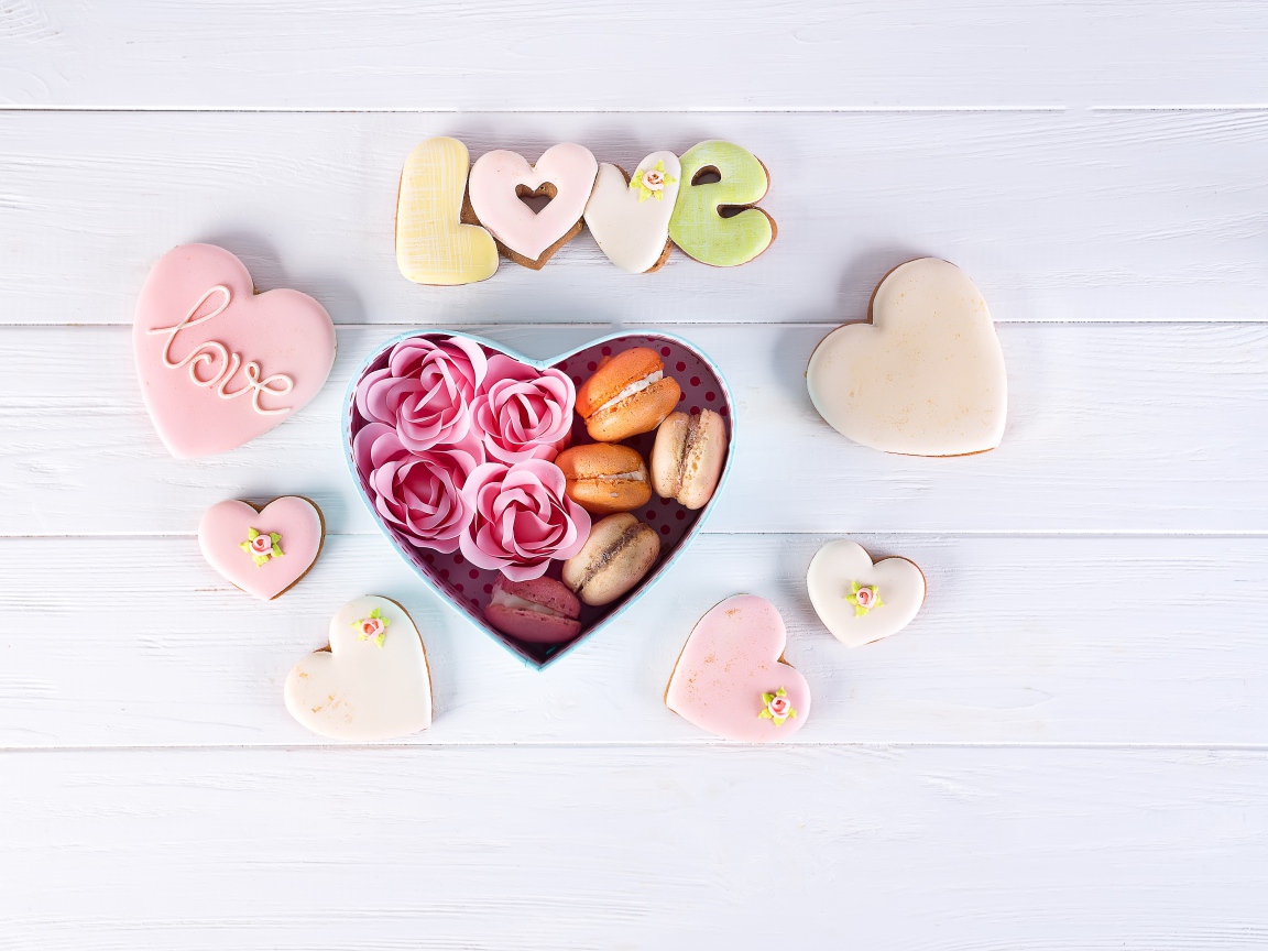 Печенье в форме сердца на столе с коробкой с десертом макарун