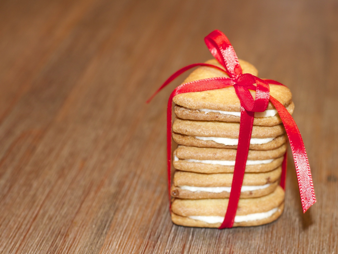 Печенье в форме сердца перевязано красной лентой 