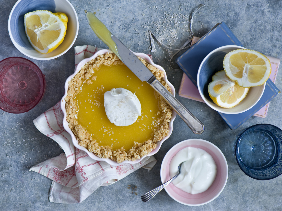 Лимонный пирог на столе с лимонами и сметаной
