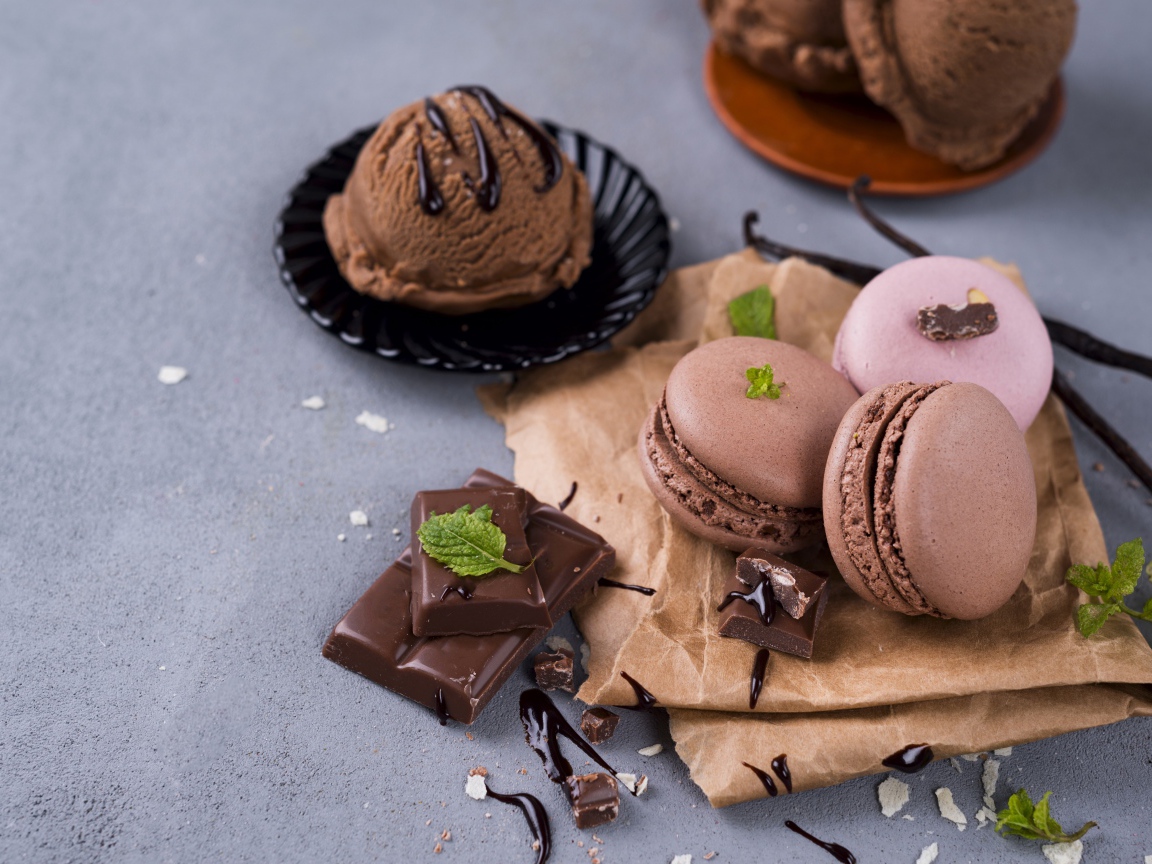 Печенье макарун на серой поверхности с мороженым и шоколадом