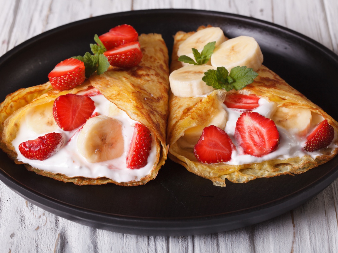 Блинчики со сметаной, бананами и клубникой на сковороде 