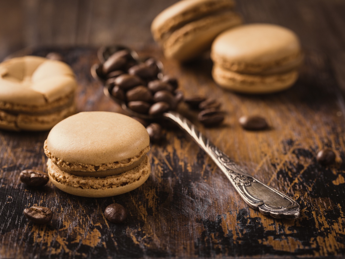 Печенье макарон на столе с ложкой и кофейными зернами