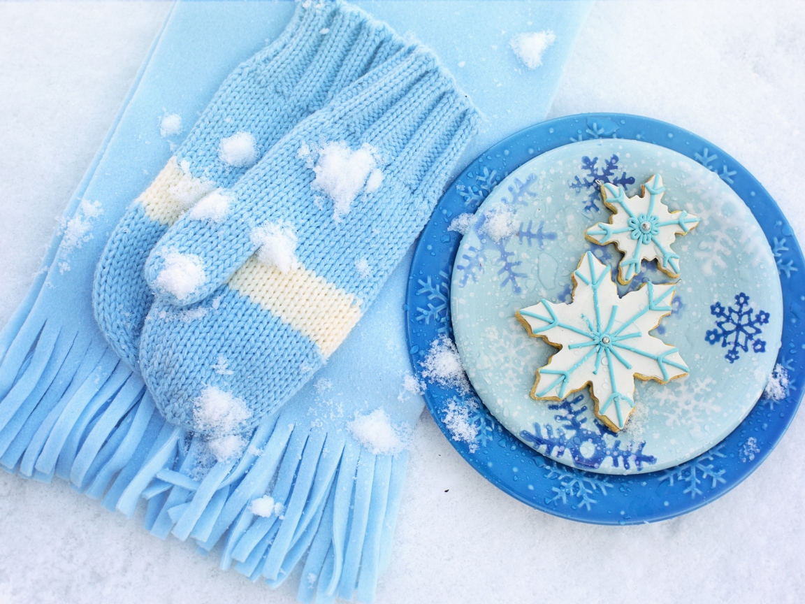 Печенье снежинки на снегу с шарфом и рукавицами