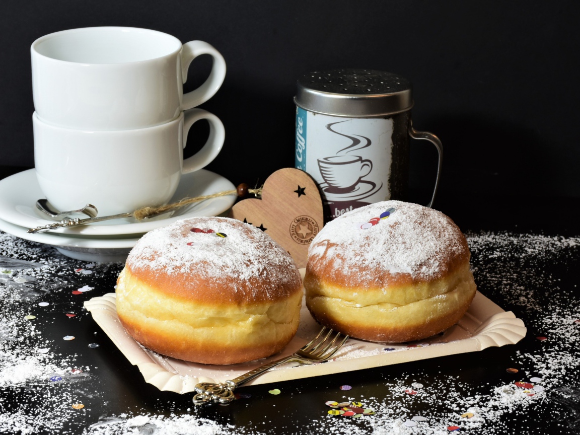 Два пончика с сахарной пудрой на черном фоне с белыми чашками