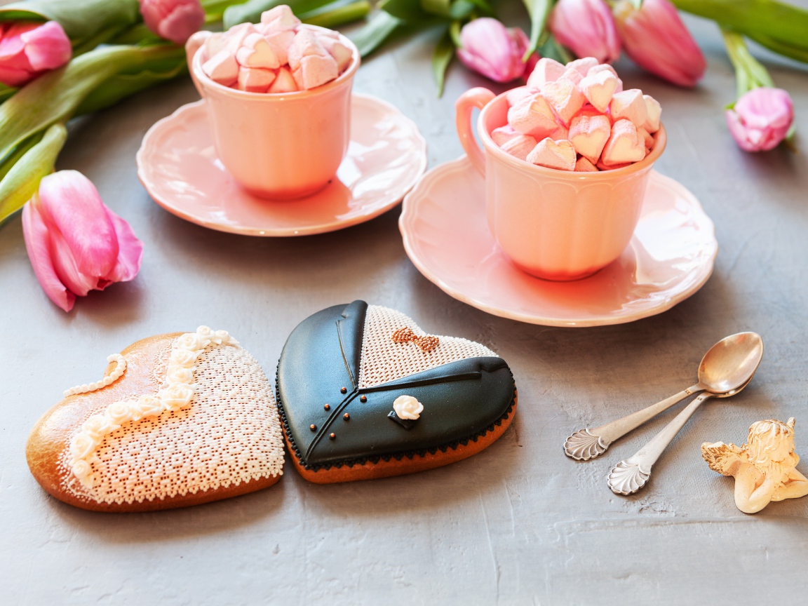 Две розовые чашки с маршмеллоу на сером фоне с печеньем и тюльпанами