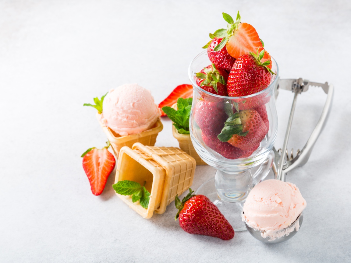 Вафельные стаканчики с мороженым на столе со свежей клубникой