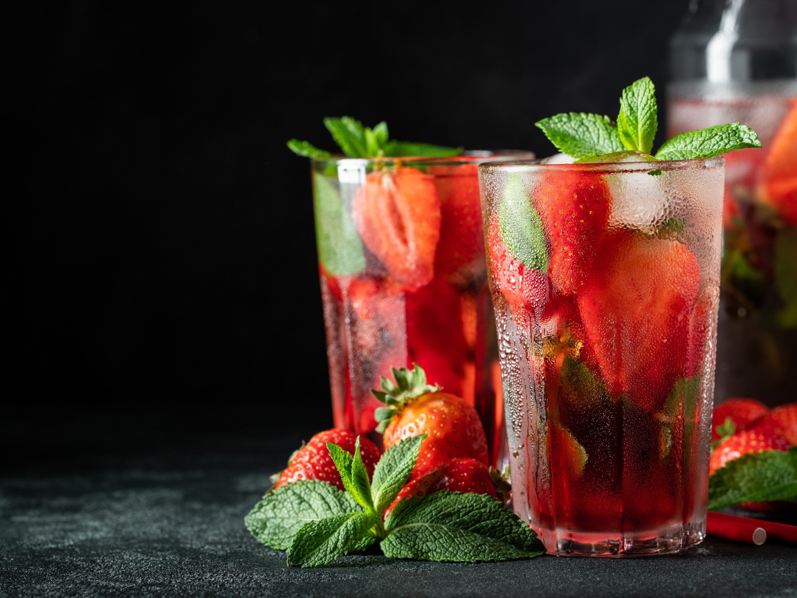 Холодный напиток в стакане на столе с клубникой и мятой
