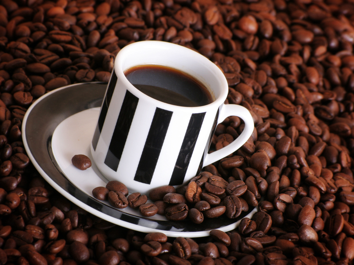 Чашка кофе на столе с кофейными зернами