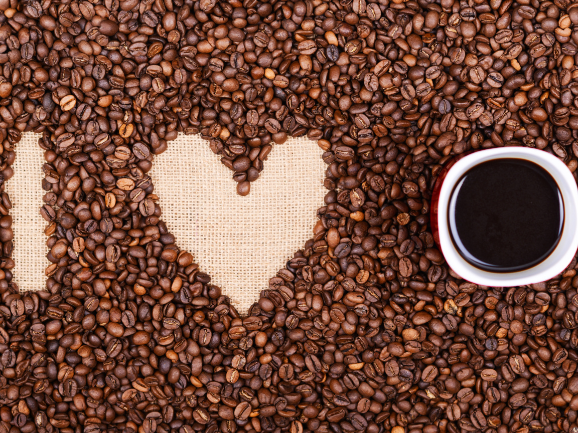 Чашка с кофе стоит на кофейных зернах 