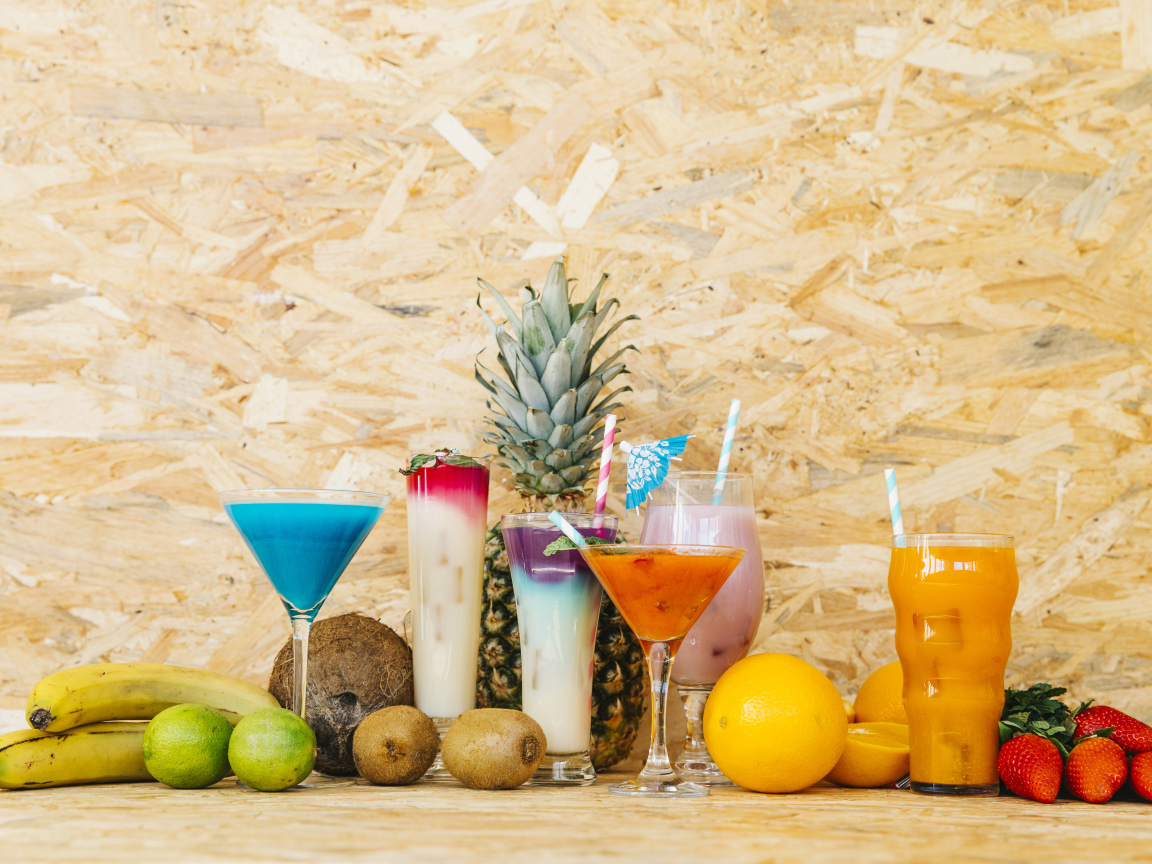 Разные коктейли на столе с фруктами 