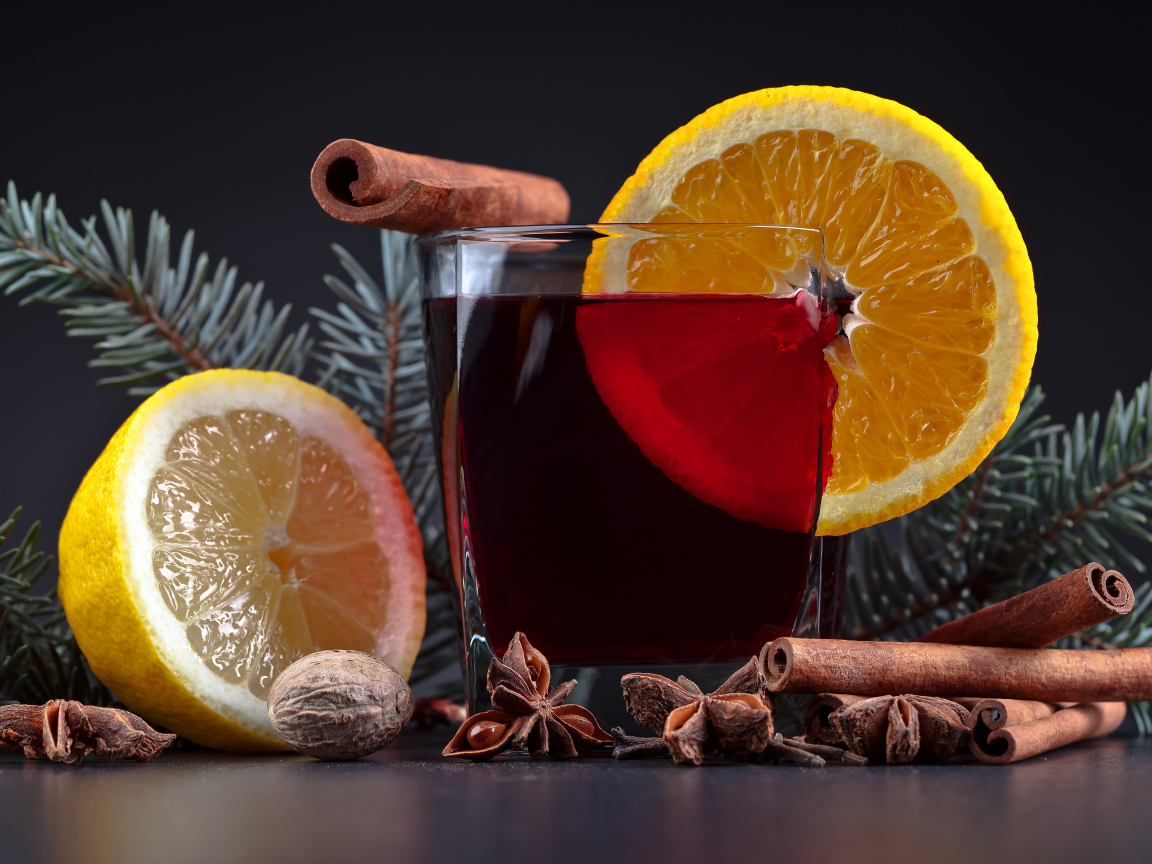 Чай с лимоном, корицей и бадьяном на сером фоне с еловой веткой