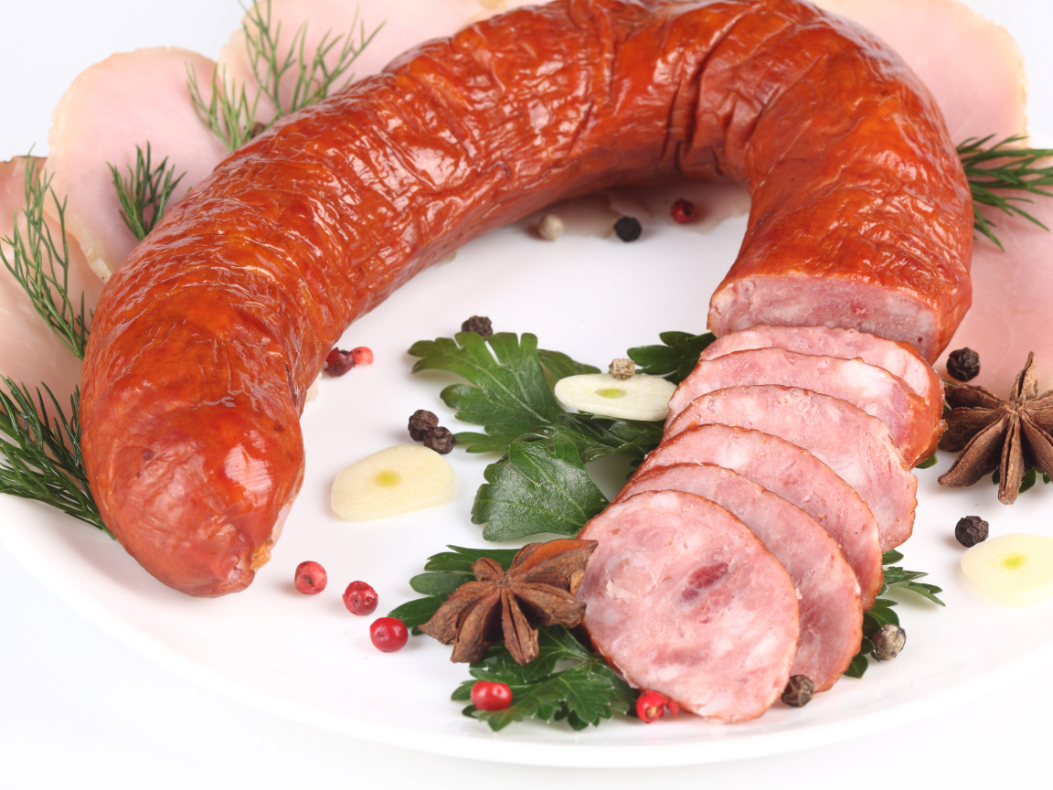 Аппетитная колбаса на белом фоне со специями и зеленью