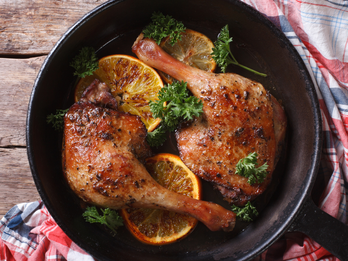 Куриные окорочка в сковороде с кольцами апельсина и петрушкой