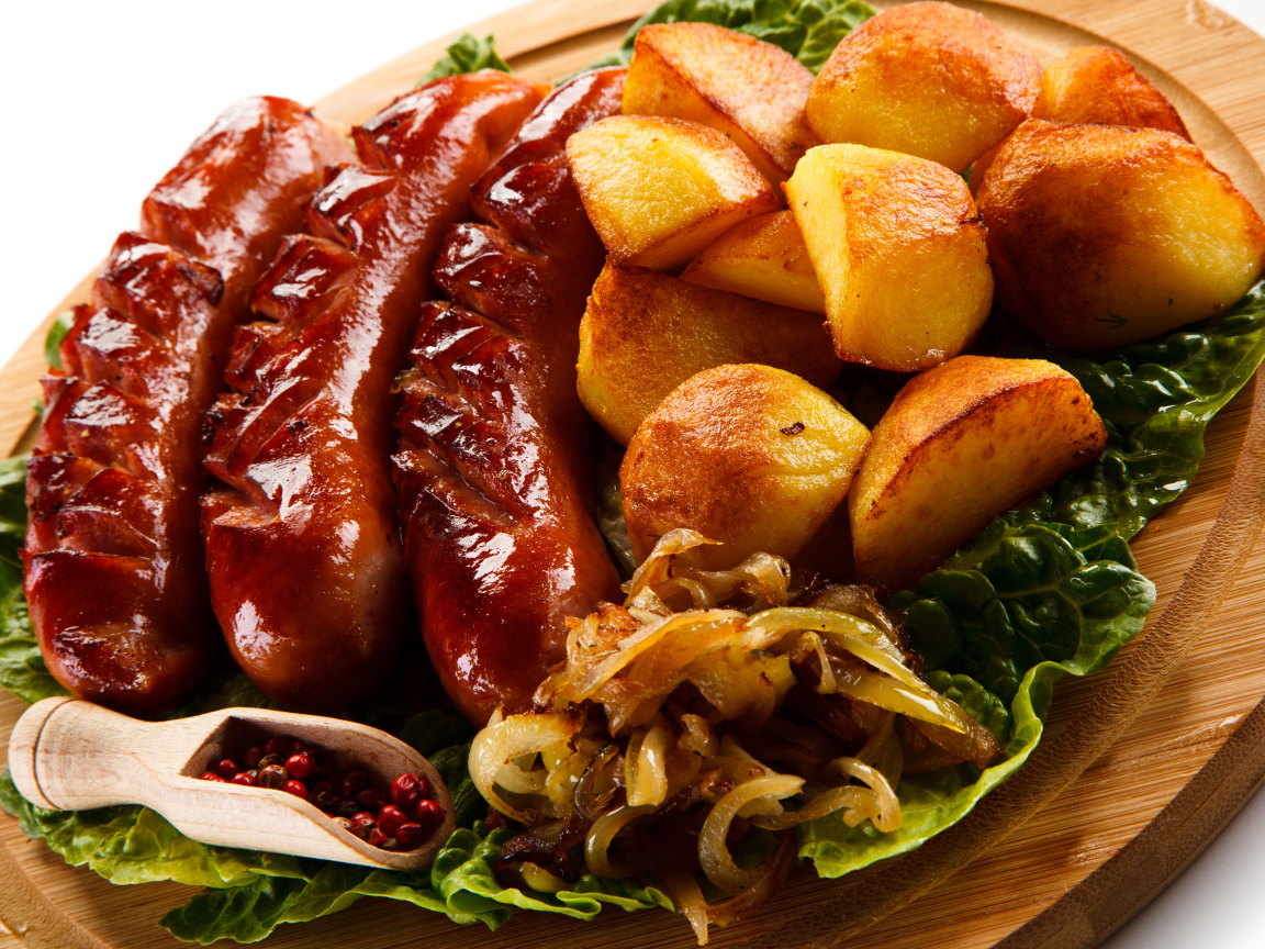 Сосиски гриль на доске с картофелем, жареным луком и перцем