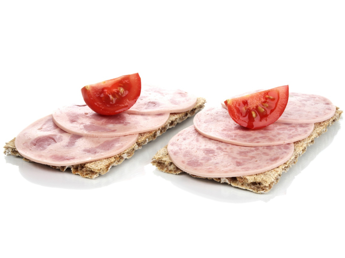 Тосты с колбасой и кусочками помидора на белом фоне