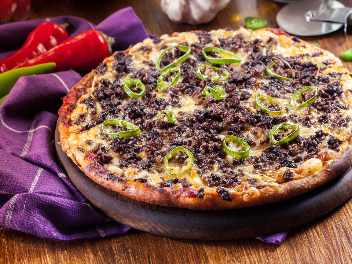 Пицца на доске с мясом и перцем 