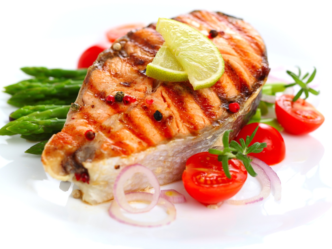 Кусок жареной рыбы с овощами на белом фоне 