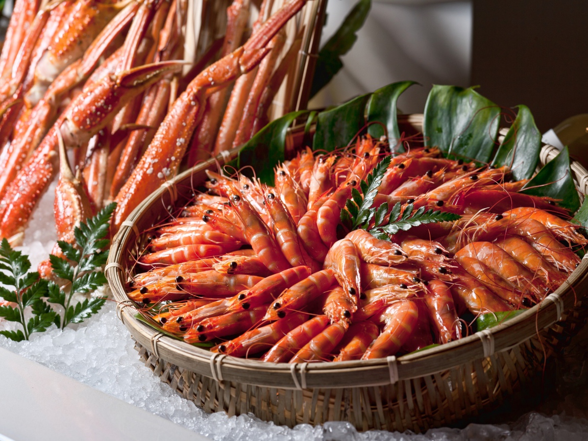 Вареные креветки лежат в корзине на столе крабами
