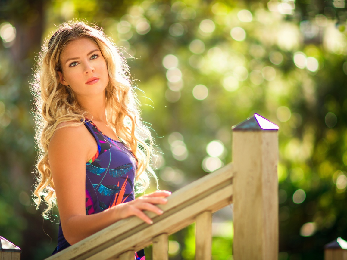 Красивая блондинка у деревянных перил 