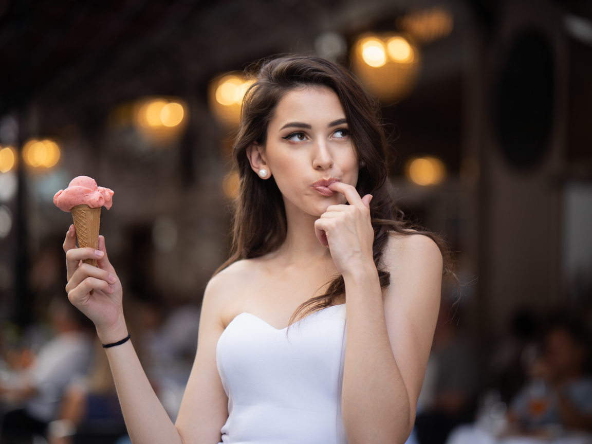 Красивая девушка шатенка с мороженым в руке