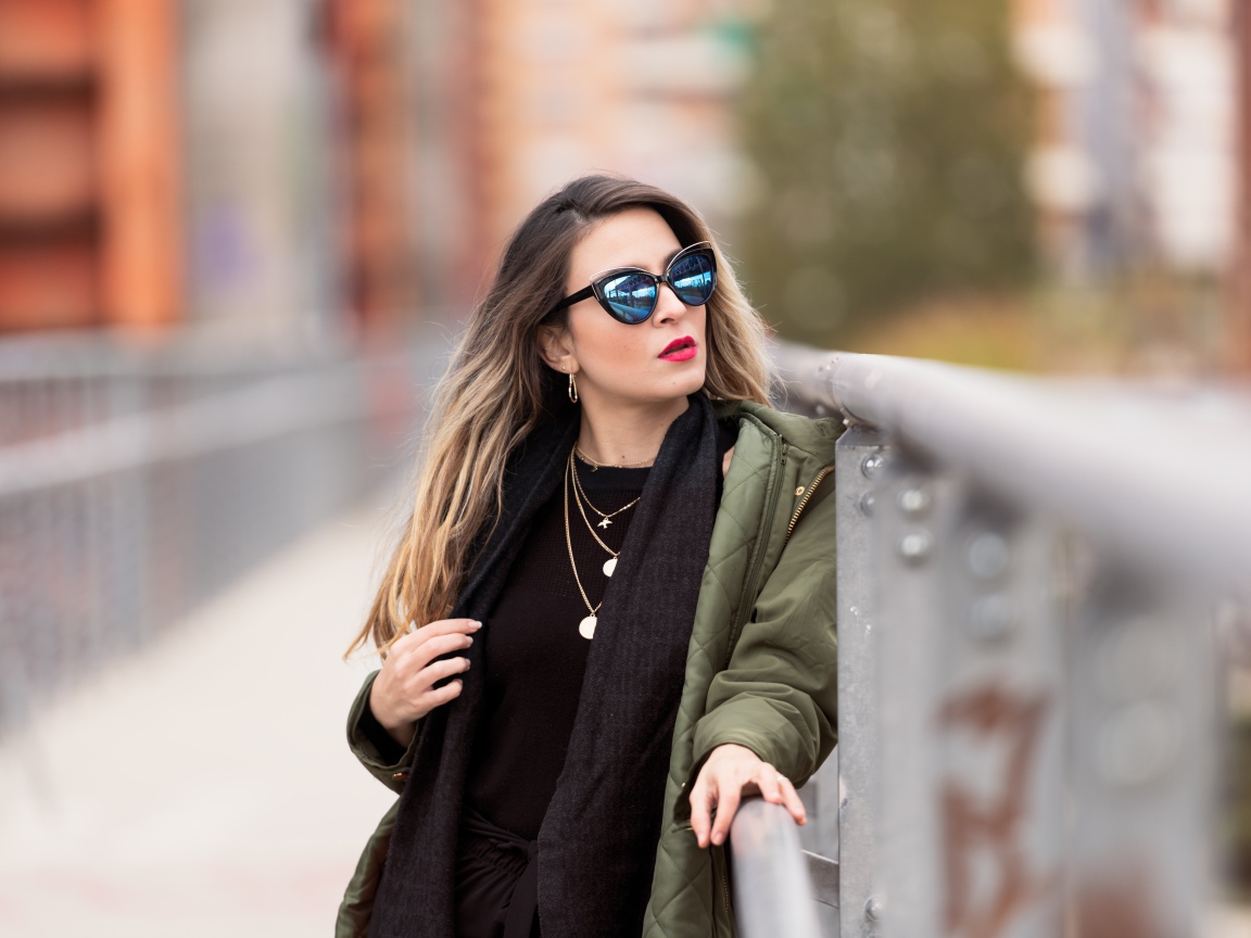 Красивая девушка в солнечных очках на мосту