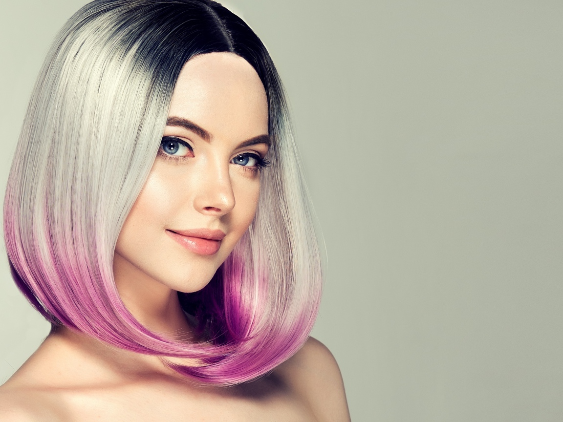 Красивая девушка с крашеными волосами на сером фоне