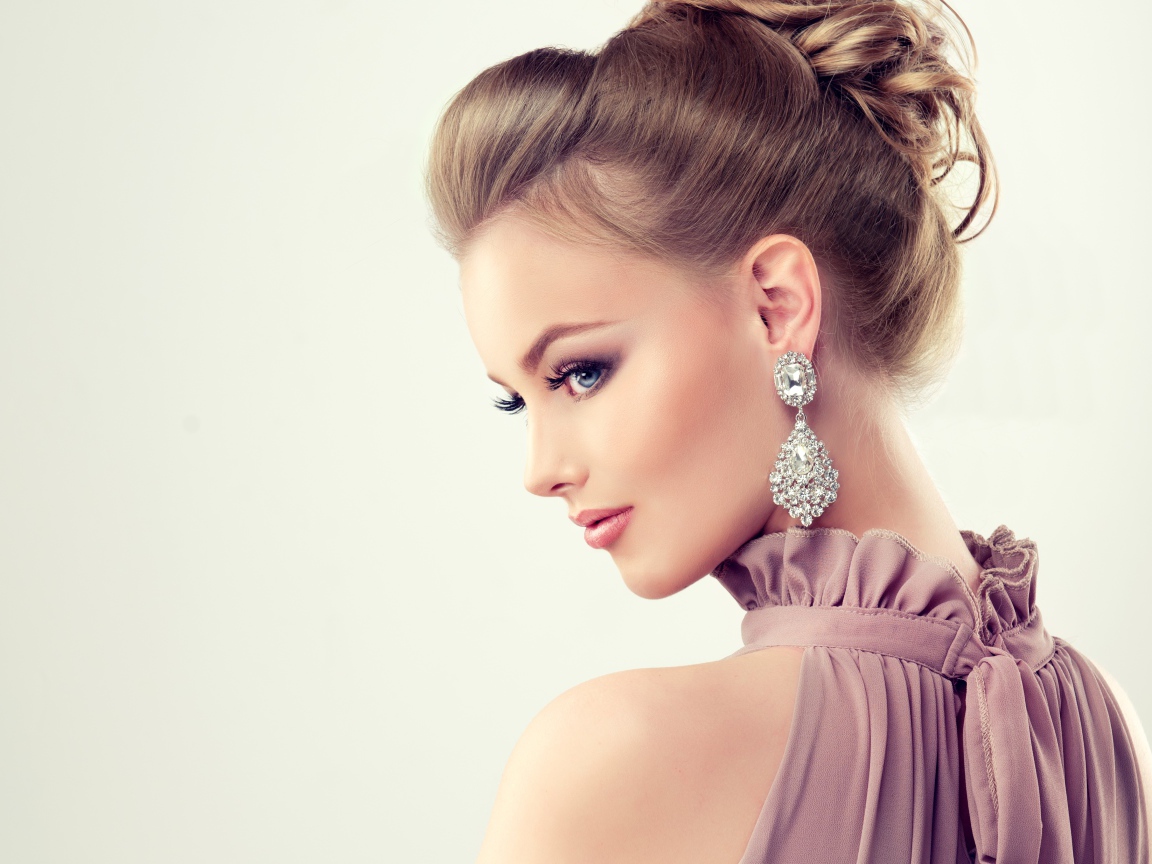 Красивая девушка с макияжем и прической на сером фоне