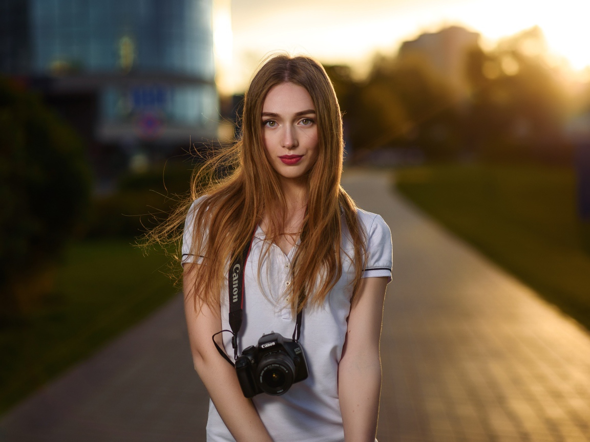 Красивая длинноволосая девушка с фотоаппаратом
