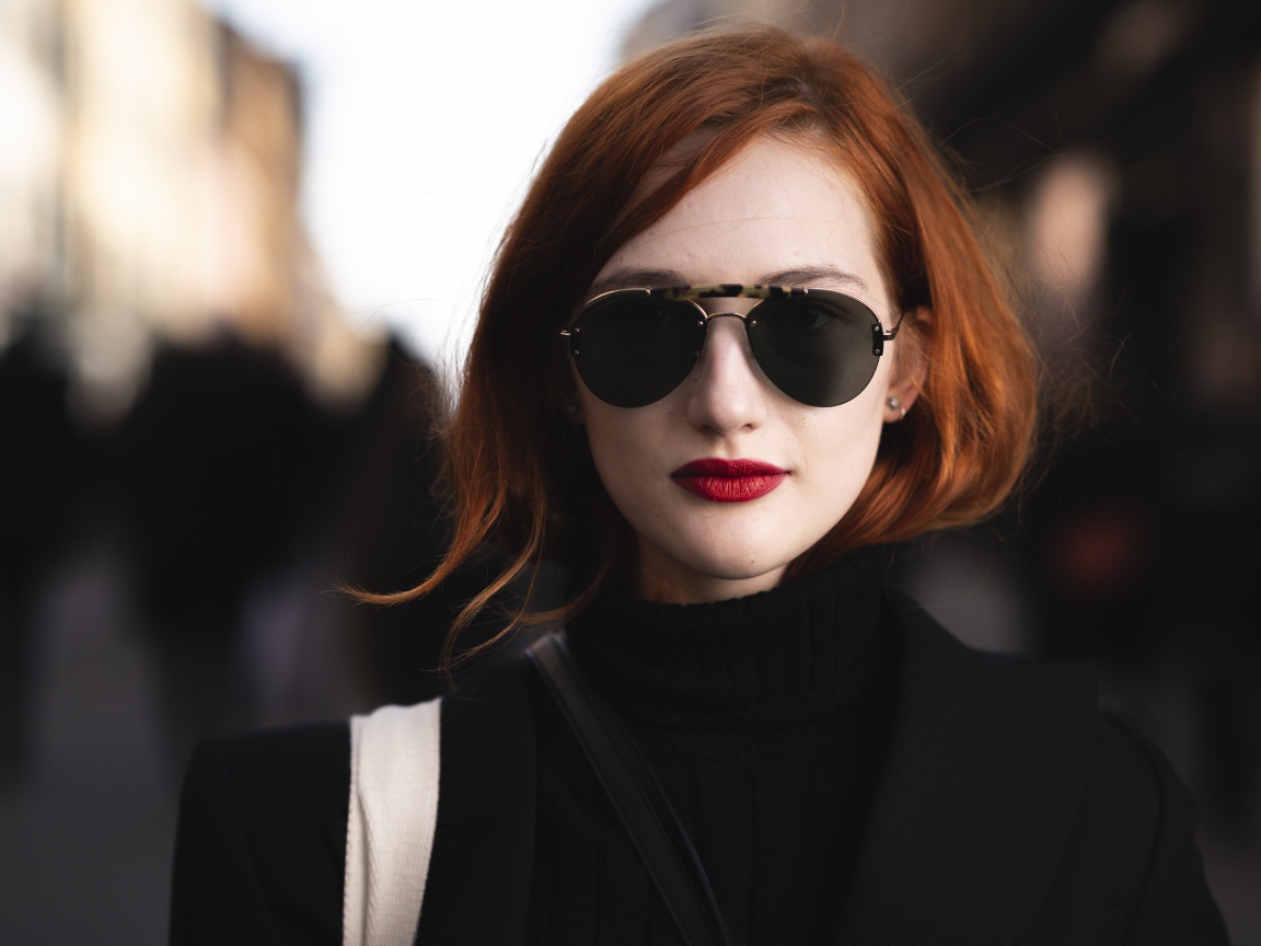 Красивая рыжеволосая девушка в темных очках