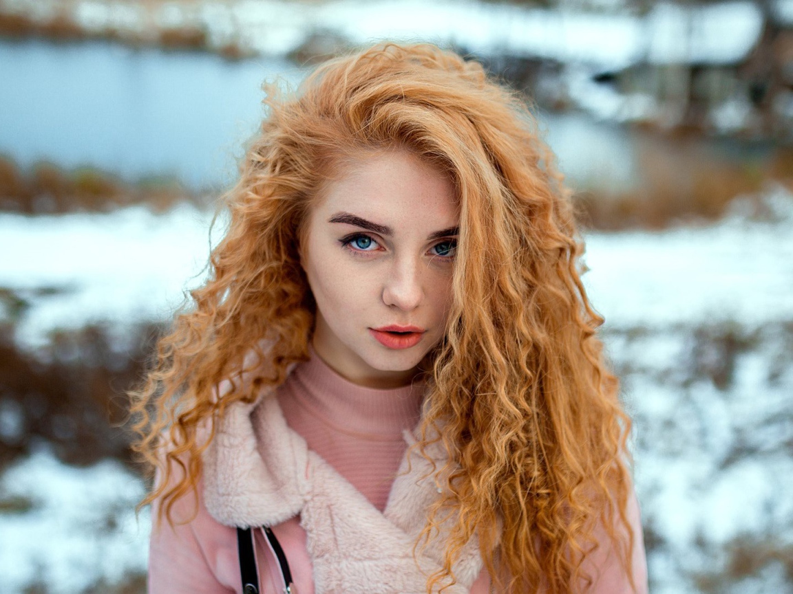 Красивая рыжеволосая девушка с голубыми глазами зимой