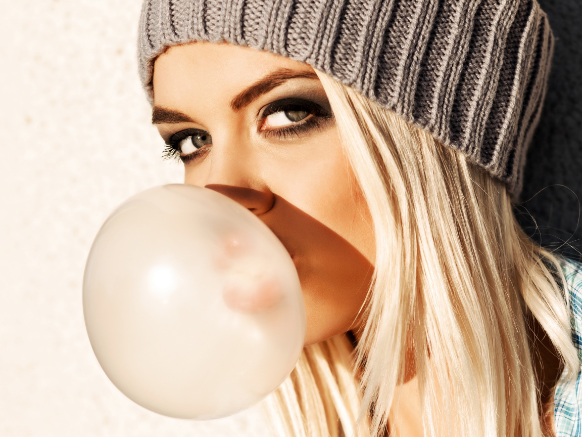 Девушка блондинка с жвачкой во рту крупным планом