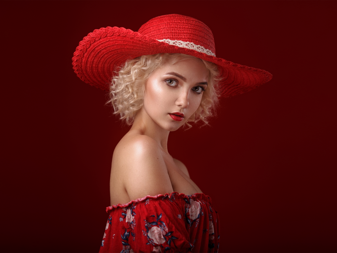 Блондинка в шляпе на красном фоне