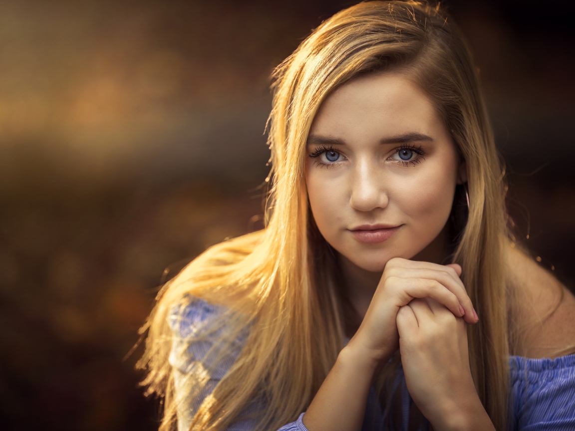 Милая голубоглазая девушка в лучах солнца