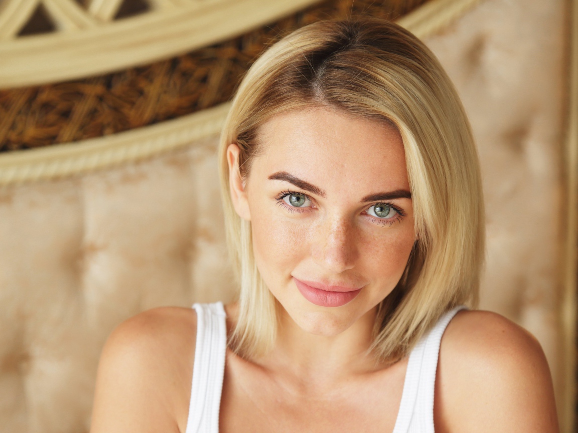 Нежная блондинка с зелеными глазами в белой майке
